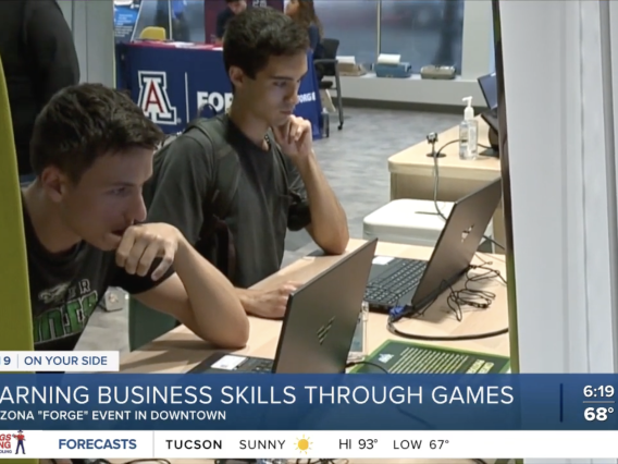 Two people looking focused while playing Venture Valley. Headline: Learning business skills through games.