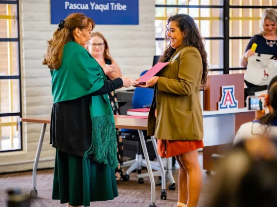 Nicolette Gomez, right, presents a certificate to Suzie Francisco