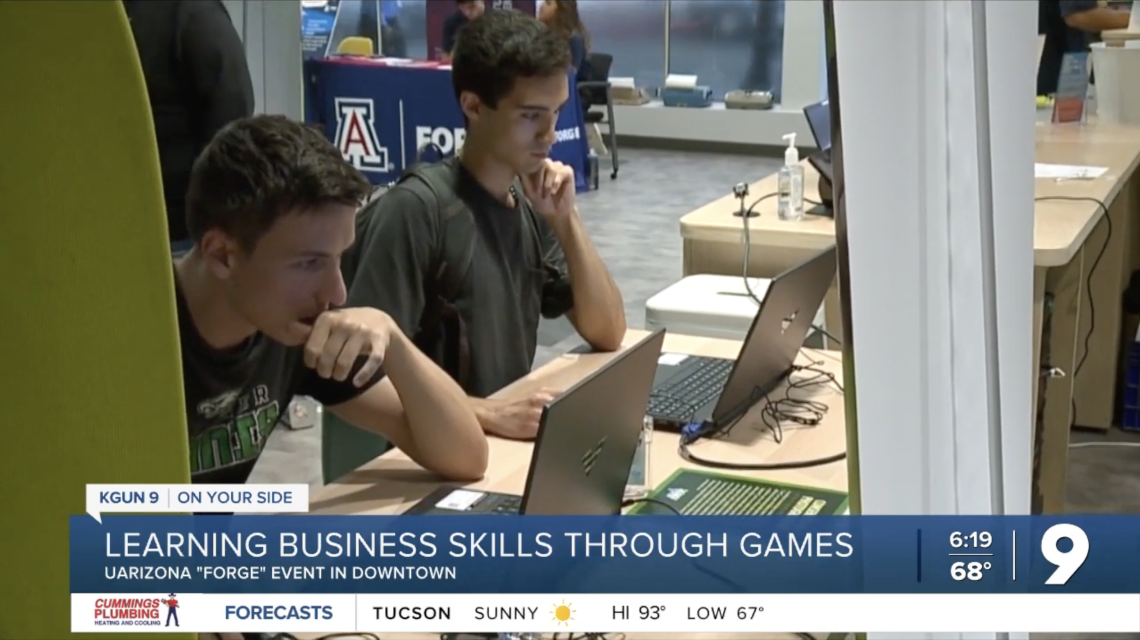 Two people looking focused while playing Venture Valley. Headline: Learning business skills through games.