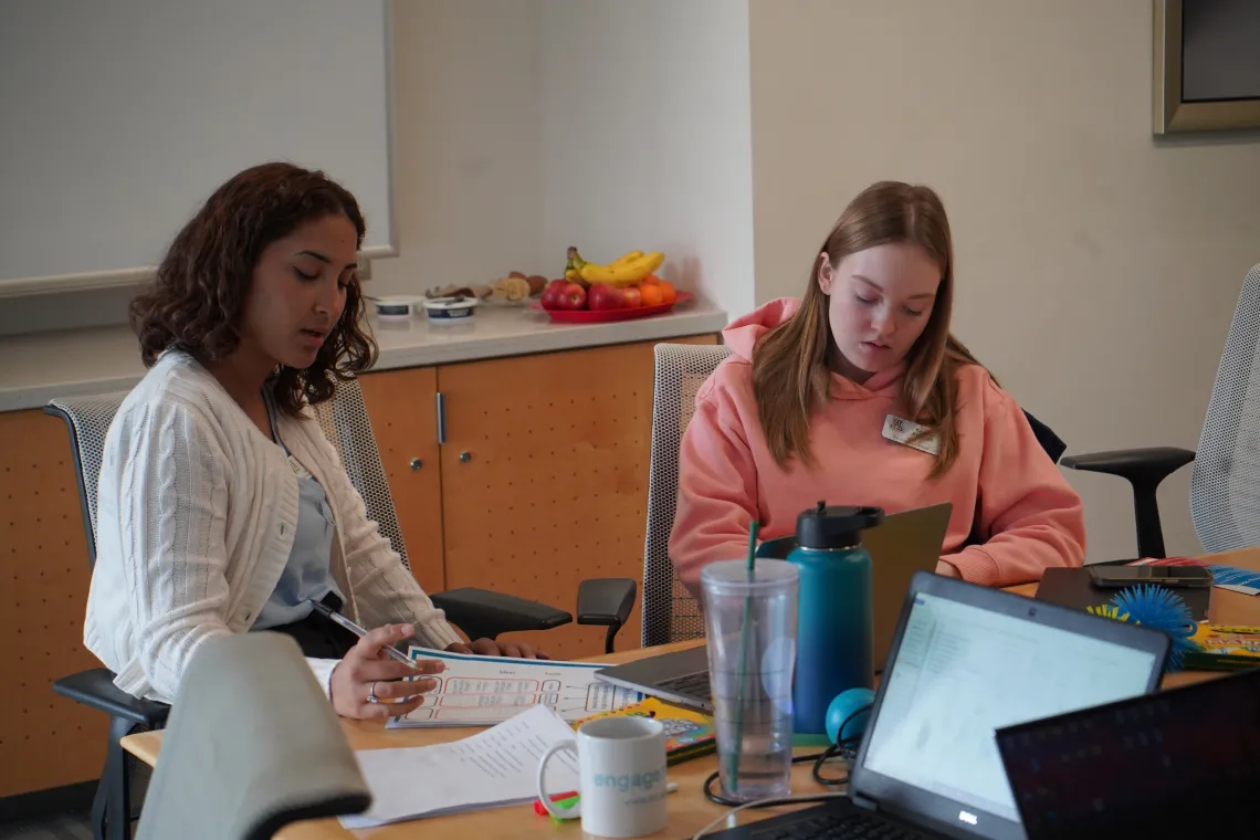 Two students writing assignments.